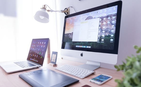木目のデスクを基調とした、Apple社製のデバイスが中心の明るめのデスク環境