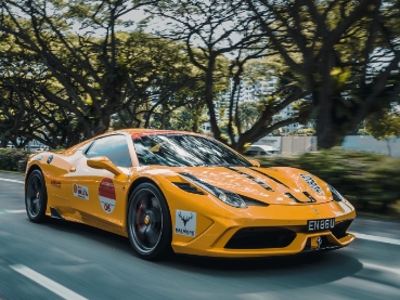 街中を走るフェラーリ製の黄色いスポーツカー
